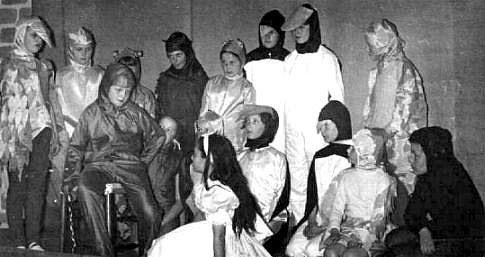 Select this image to see a larger version. Julia Packer (The Mouse) sitting tells her tale to Linda Bradley (Alice)  watched by various Animals, including Philippa Kitchen - standing second left - and Margaret Tweedy - front second right.

