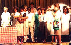 Left: Dorothy (Lisa Gater) with Toto, the dog. Right: Aunt Em (Janine Britton) and the chorus with 'The Feeling We Once Had' Select this image to see a larger version. 