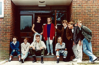 A break from rehearsals outside Curzon Centre, 1986. L2R: ?, ?, Edward Thornton (seated), ?, Anne-Marie Crawford (red cardigan), Tania Schnadhorst, Royston Northridge (brown jacket), Matthew Humberstone, Jeremy Murrell.